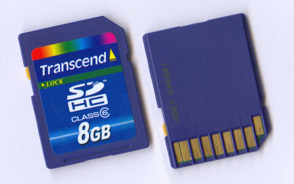 Paměťová karta SDHC o kapacitě 8 GB vyfocená z obou stran, vlevo potisk s kapacitou, vpravo kontakty