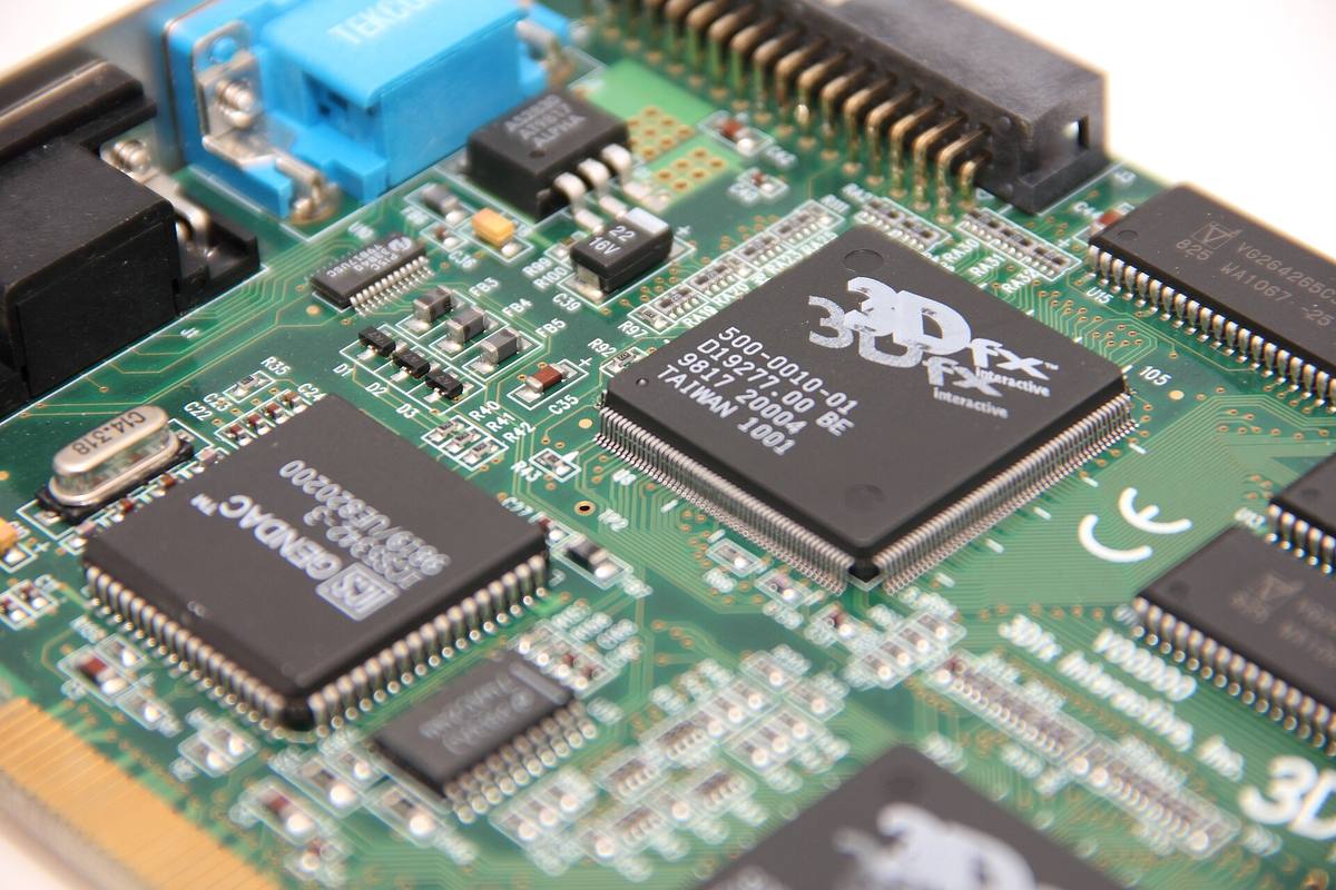 Detail zelené grafické karty, uprostřed velký čip s logem 3dfx, kolem něj paměťové obvody
