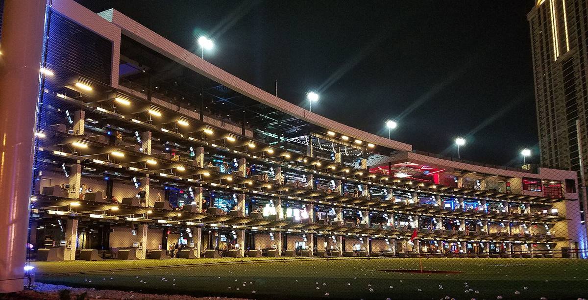 Několik pater osvětlených odpališť areálu Topgolf v Las Vegas po setmění