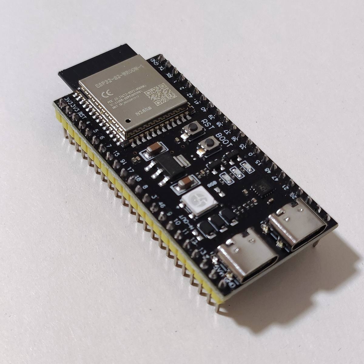 Vývojová deska ESP32-S3-DevKitC-1 s modulem ESP32-S3-WROOM-1 ležící na bílém papíru