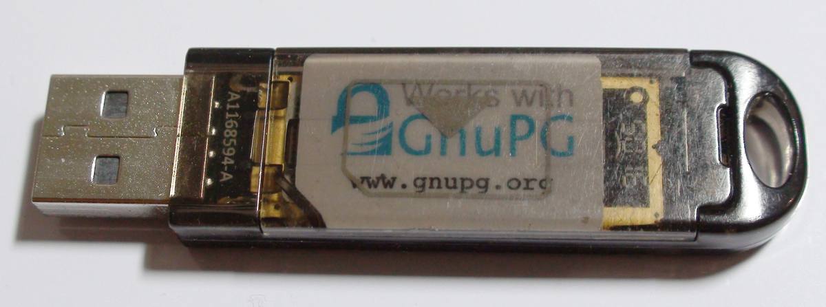 Průhledné USB pouzdro s vylomenou čipovou kartou OpenPGP a nálepkou Works with GnuPG